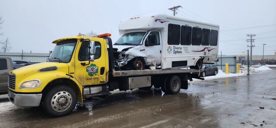 Lucky 7's yellow flatbed recovering a shuttle bus in a Wisconsin winter